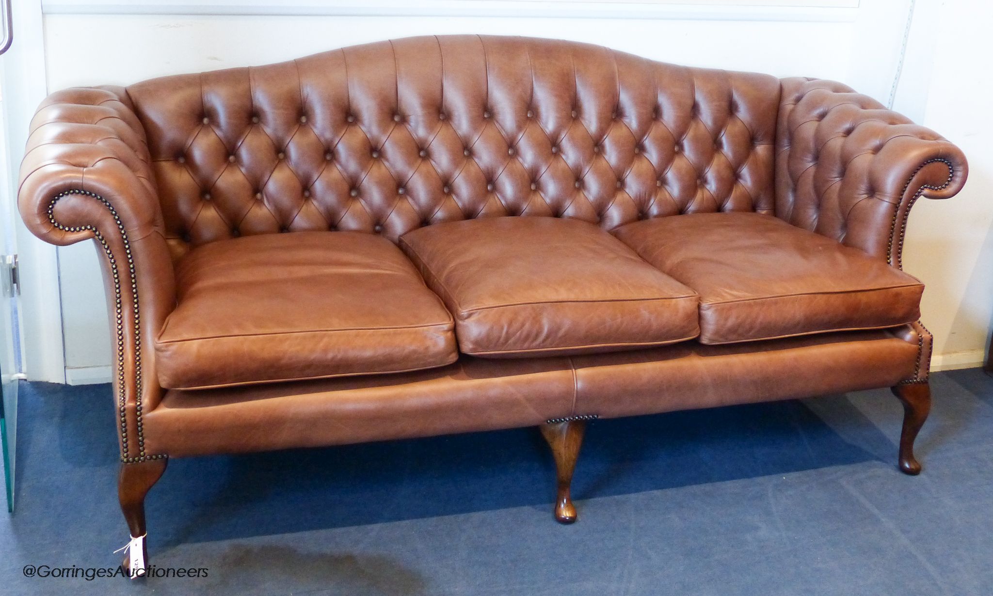A George III style buttoned tan leather camel back sofa, 210 cm wide